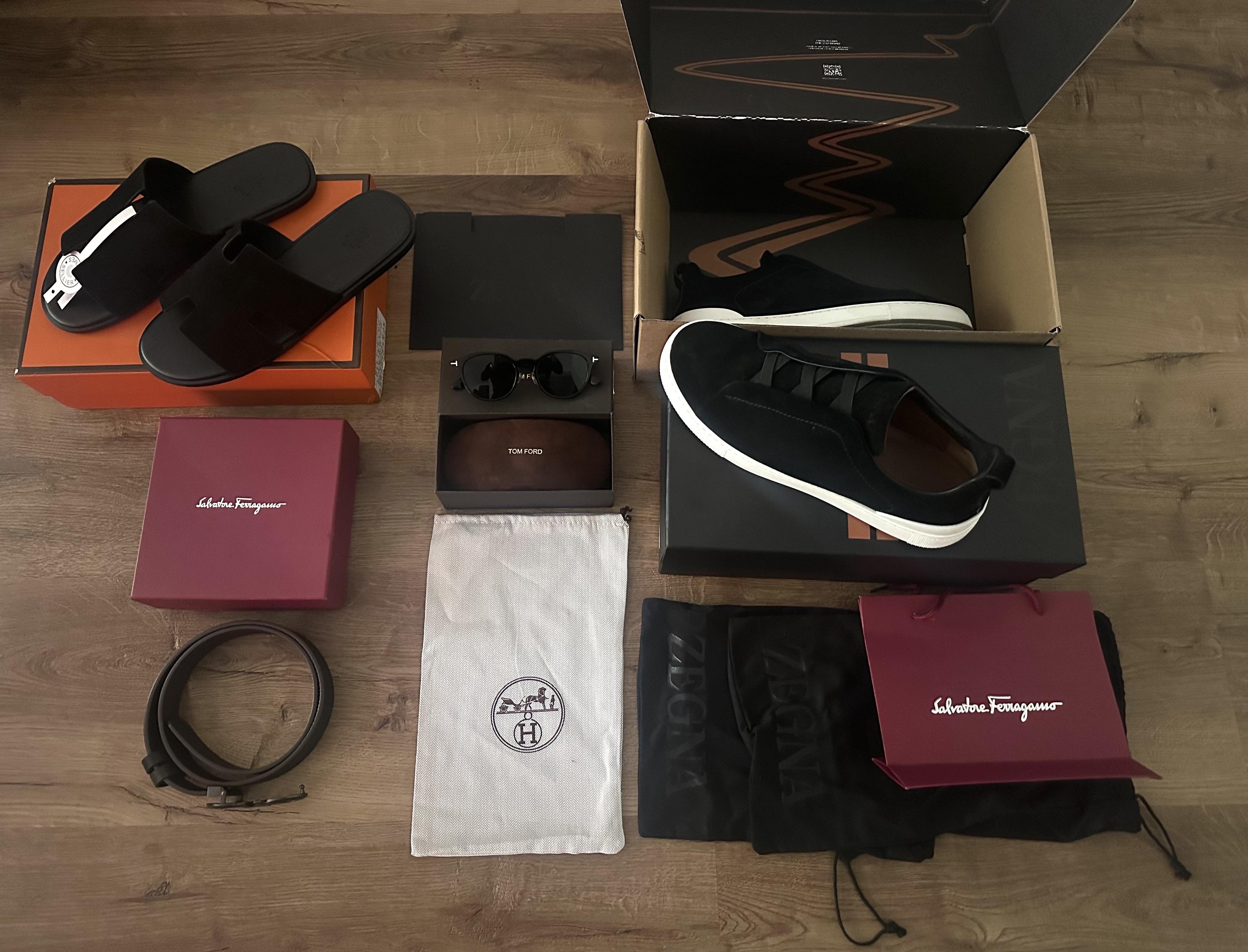 Shoes, sunglasses, belt and packaging arranged in the Reddit author's Germany haul photo
